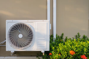5 Tips to Choose the Best HVAC System for Your Wisconsin Home. Air conditioning system installation embedded on wall of building.