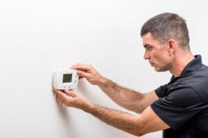 Man Troubleshooting Thermostat