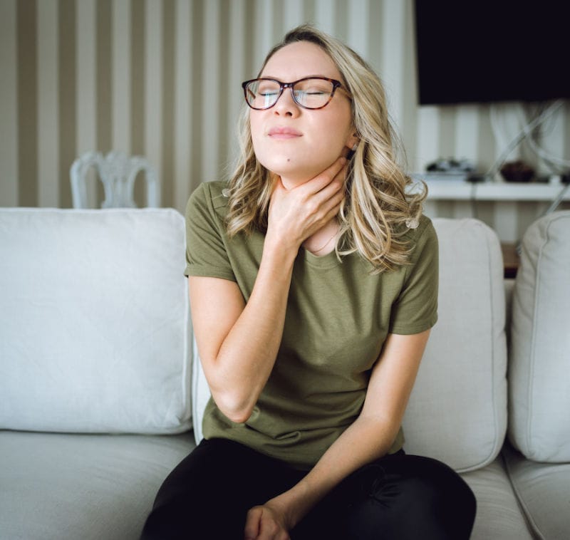 Young Woman with sore throat at home