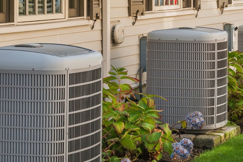AC Maintenance Special in Mukwonago. Photo of two HVAC units installed outside of a home or building.
