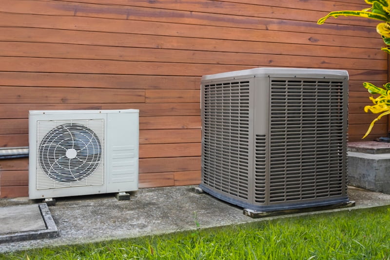 Heat Pump and Central Air Conditioning Condenser Units Installed Outside a Home in Mukwonago, WI