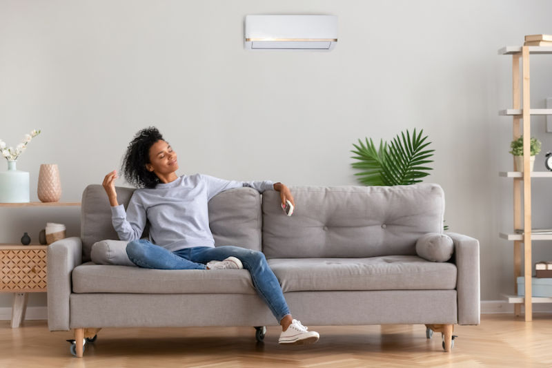 young relaxed woman sitting on couch breathing fresh air