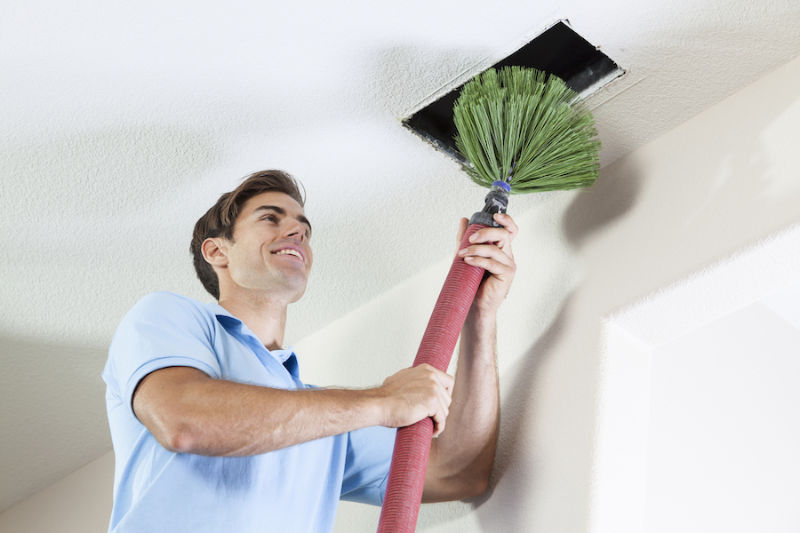 Man cleaning air ducts in home.